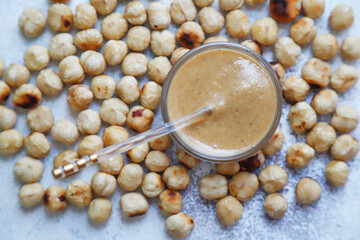 Homemade nuts butter in a glass jars with various nuts.