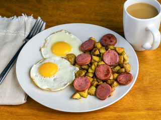 two fried eggs  with home fries and kielbasa