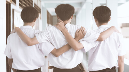 Three friends hugged each other on the day of graduation. A group of male students stood hugging each other before parting in the future.Concept of best friends