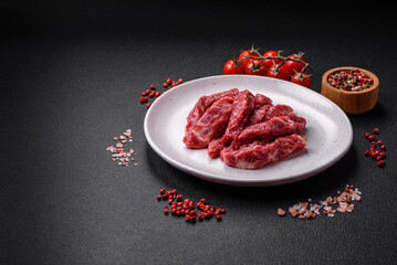 Fresh juicy raw beef slices with salt and spices