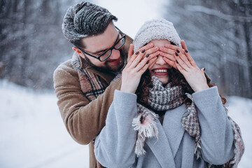 Man hiding his wifes eyes to offer her an engagement ring for a marriage proposal. Christmas time....