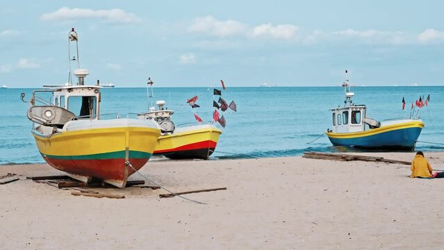 Undecked Handliner Fishing Vessel with Net Flags and Rusty Hooks Purse Sein Equipment Parked on Beach Sand at Seashore on Calm Day