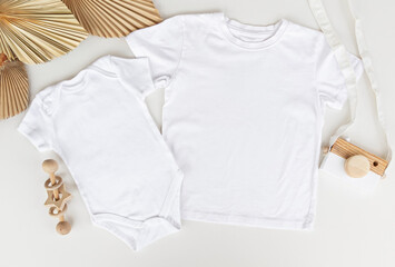 2 White new baby bodysuit  and t shirt on white background. Sister brother design. Closeup. Empty place for text or logo on apparel. boho .Top down view.