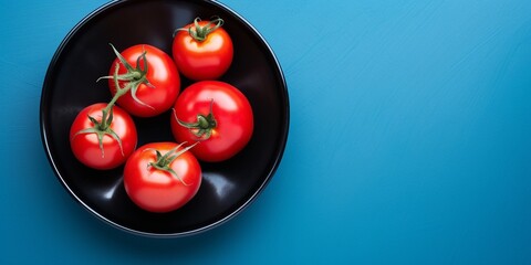 Top view of red ripe tomato in black ceramic dish on blue background with copy space : Generative AI