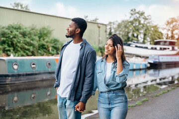 couple walking and hugging on the quays, pier, looking at yacht, sailboat, boat, having a fun,...
