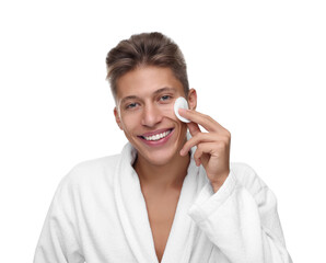 Handsome man cleaning face with cotton pad on white background