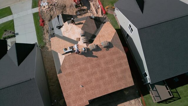 Roofer repair or replace shingle that has been damaged and needing replacement at sunny day. Aerial view