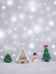Christmas tree, Miniature house with shiny light for Christmas and New Year holidays background, Winter season, falling snow, Copy space for Christmas and New Year holidays greeting card.
