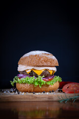 Beef burger with lettuce, tomato, cheddar cheese and onion