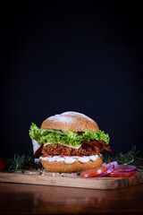 Chicken burger with lettuce, tomato, cheddar cheese and onion