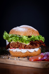 Chicken burger with lettuce, tomato, cheddar cheese and onion