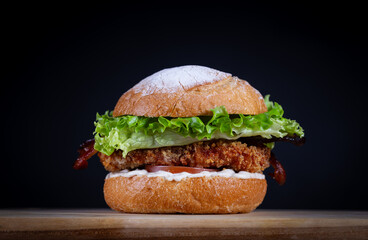 Chicken burger with lettuce, tomato, cheddar cheese and onion