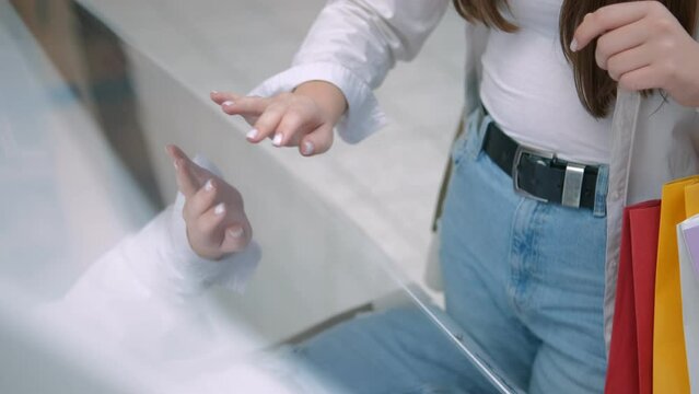 Young beautiful woman looking for information and location of shopping place on digital touch screen in shopping mall 4K