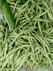 Bean vegetables on a shelf in a traditional market.