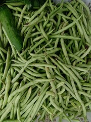 Bean vegetables on a shelf in a traditional market.