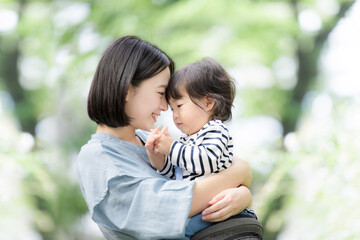 Mother holding her child in green Asian mother and child (Japanese) gazing at each other Images of...
