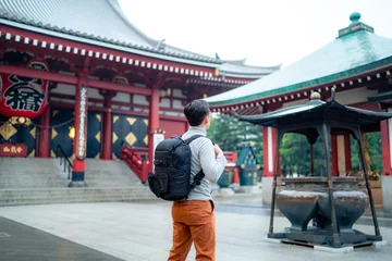 Fotobehang Back view full body of unrecognizable Hispanic tourist backpacker standing on street tiled pavement against entrance of Japanese Sensoji temple in Asakusa Tokyo, Japan © Itza