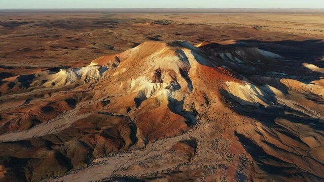 Aerial drone pan shot of beautiful landscape of Arckaringa Desert Painted Hills in outback South Australia at sunrise