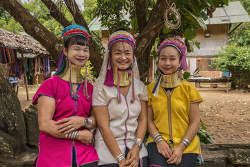 portrait of three long-necked Karen women with brass neck rings at Pai in Mae Hong Son, Thailand