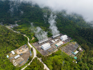 View from above of Geothermal power station with steam and pipes. Renewable energy production at a...
