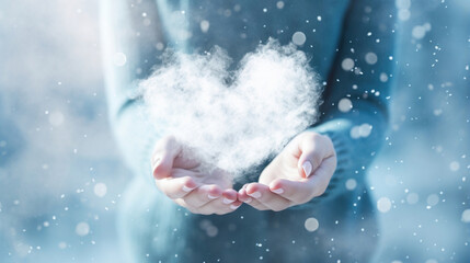 A woman's hands hold a white cloud in the shape of a heart on a blue background
