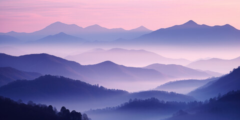 Fototapeta premium The mountains are shrouded in mist, and the last traces of daylight lend a tranquil, mystical quality to the scene. A twilight shot of autumn mountains under a fading pink and purple sky.