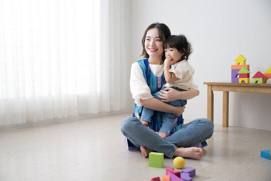 A preschool teacher and a child (caregiver) playing with building blocks Image of babysitter Full body