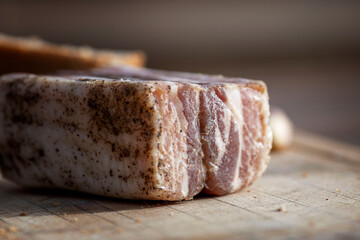 Appetizing pieces of lard with garlic on a wooden board. A traditional dish of Russian and Ukrainian cuisine. Close-up.