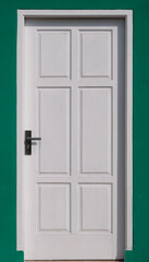 Front white door in green wall background
