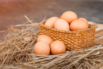 Brown and white eggs in a traditional wicker basket and a natural nest are fresh, healthy, raw ingredients for breakfast