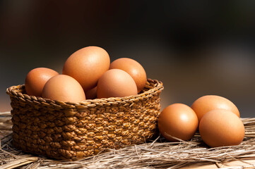 Chicken eggs in basket on wooden background