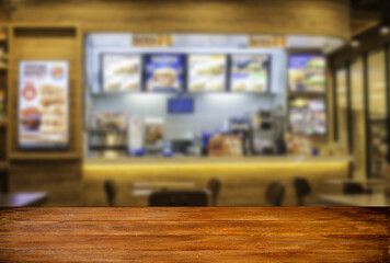 Wood table blank screen with restaurants in the mall