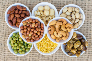 Top view mixed nuts and dried fruits in a bowl on sack background