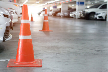 Red traffic cones at parking area in mall .