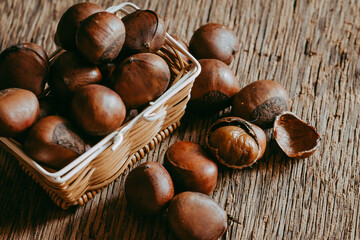 Chestnuts in mini basket on wooden background