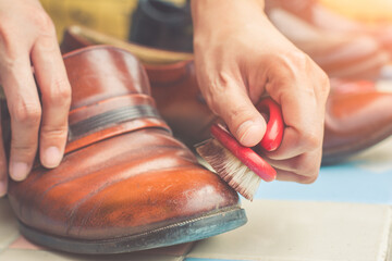 Men cleaning brown leather shoes .Polishing with brush
