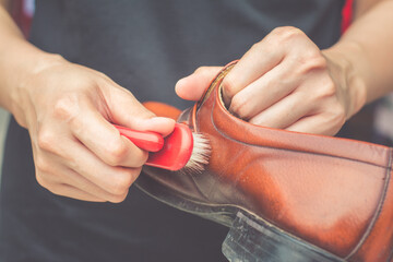 Men cleaning brown leather shoes . Polishing with brush