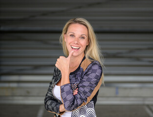 Portrait of an attractive blonde woman with her thumb on her lips