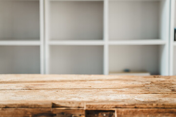 Wooden tabletop with blurred blank bookshelf - can be used for displaying and editing your products.