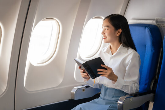 Reading a book, Thoughtful asian people female person onboard, airplane window, perfectly capture the anticipation and excitement of holiday travel. chinese, japanese people.