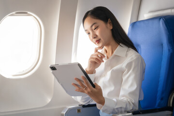 Using tablet pc, Thoughtful asian people female person onboard, airplane window, perfectly capture...
