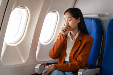 Female asian chinese japanese people passenger experiencing airsickness, clenching sick bag and...