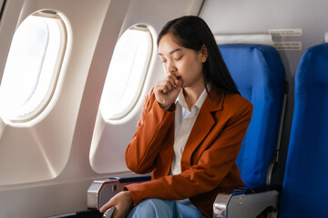 Female asian chinese japanese people passenger experiencing airsickness, clenching sick bag and...