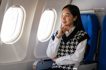 Fototapeta premium Passionate female asian chinese japanese people student aboard airplane, clutching textbooks, eagerly anticipating her overseas academic venture.