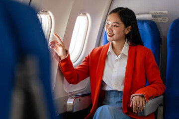 Young asian chinese japanese people female adventurer in-flight, mapping out destinations as she voyages worldwide. woman passenger of airplane. travel around the world.