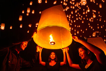 Asian couple traveller setting yi peng  lantern in loi krathong festivities