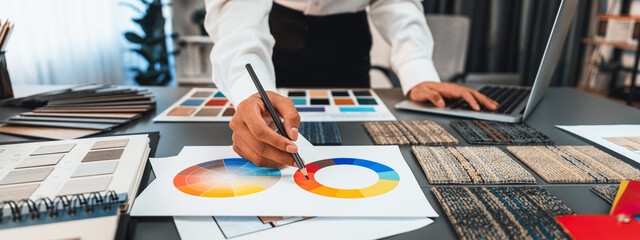 Interior architect designer at workstation table choosing various color samples art tool design...
