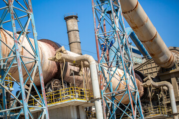 Cement factory. Pipes and compressors, equipment, metalurgy. Modern technologies work at a cement plant. Technological work on the production of cement. Working atmosphere with copy space. - obrazy, fototapety, plakaty