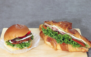 close-up images of hamburger and sandwich. Bread with vegetables and ham.
