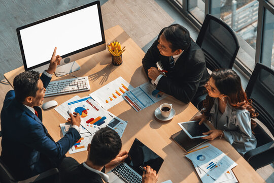 Smart businessman and businesswoman talking discussion in group meeting at office table in a modern office interior. Business collaboration strategic planning and brainstorming of coworkers. Jivy